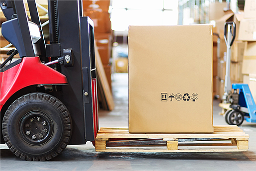 Forklift picking up pallet in warehouse