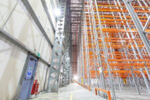 High-bay warehouse racking with galvanized uprights and bright orange beams