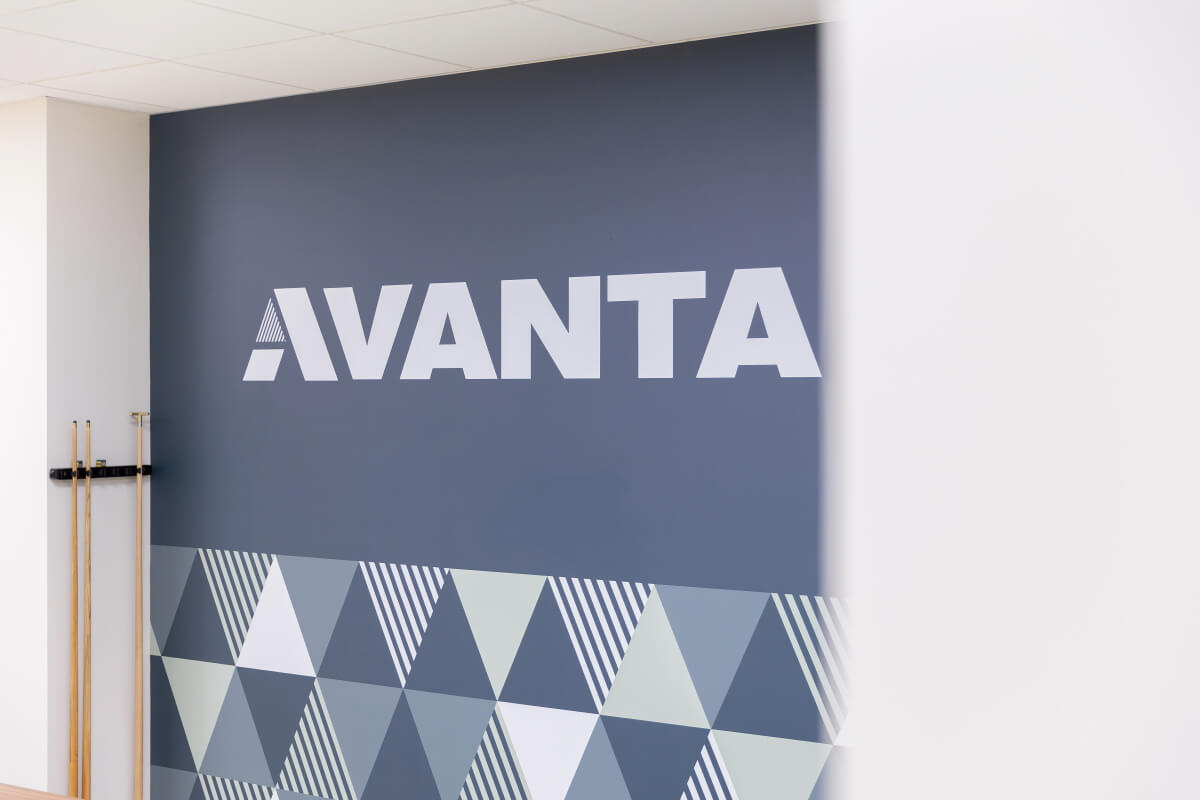 Wall with the AVANTA logo on a dark blue panel and a geometric triangle pattern along the lower edge.