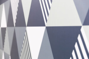 Abstract geometric pattern of gray and white triangles with diagonal striped accents